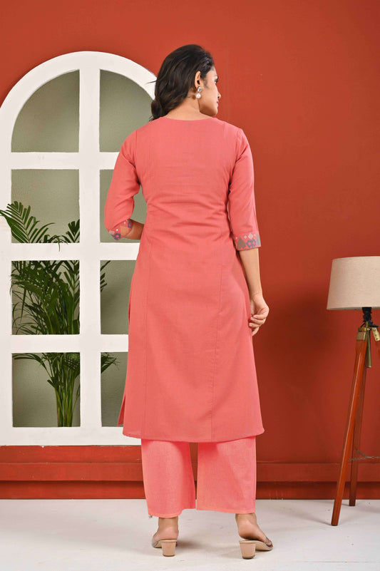 Back view of a stylish women's ethnic kurta pant set in coral pink, featuring three-quarter sleeves