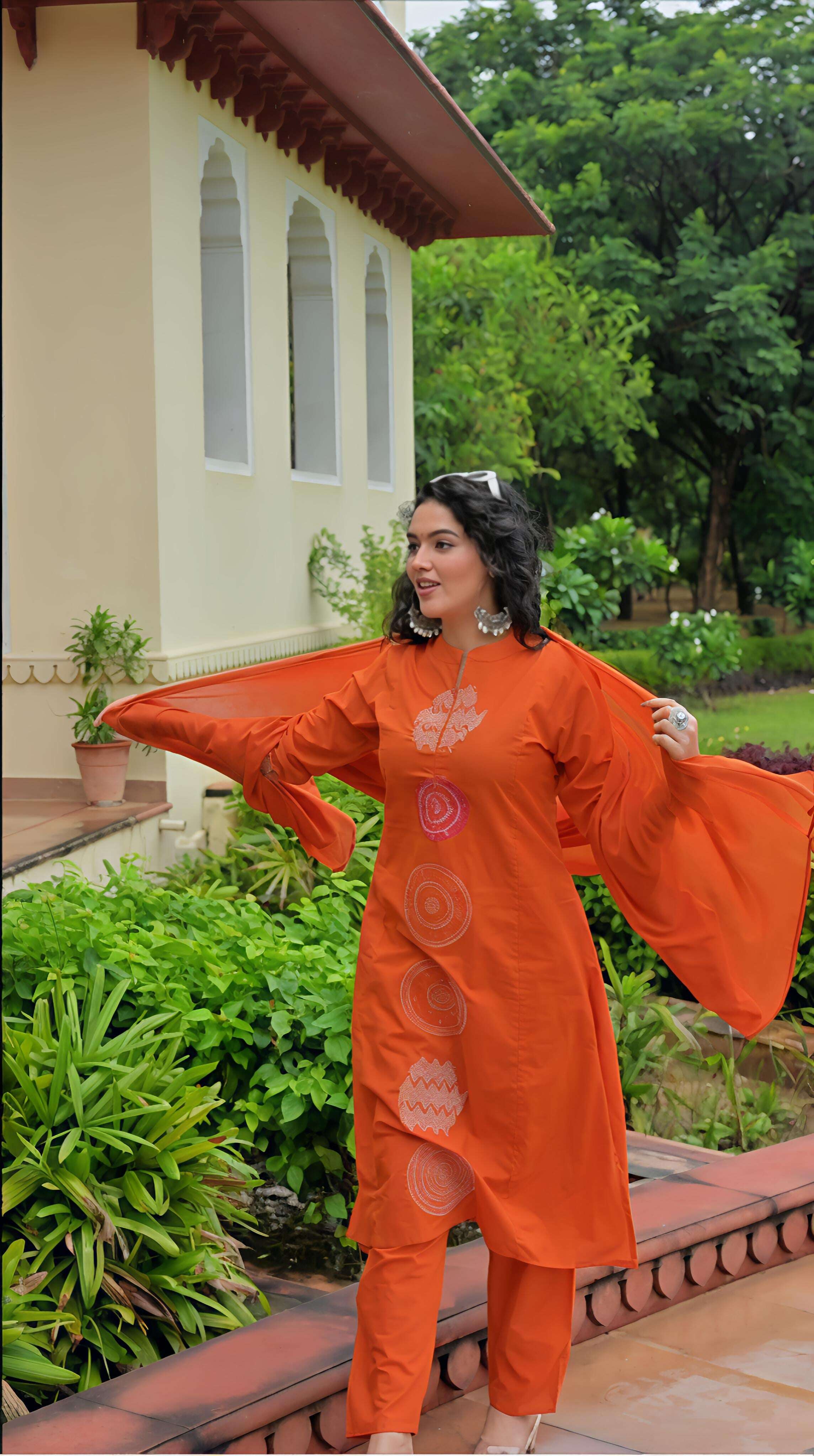 Stylish orange cotton kurta set featuring intricate embroidery and flowing sleeves for a fashionable look