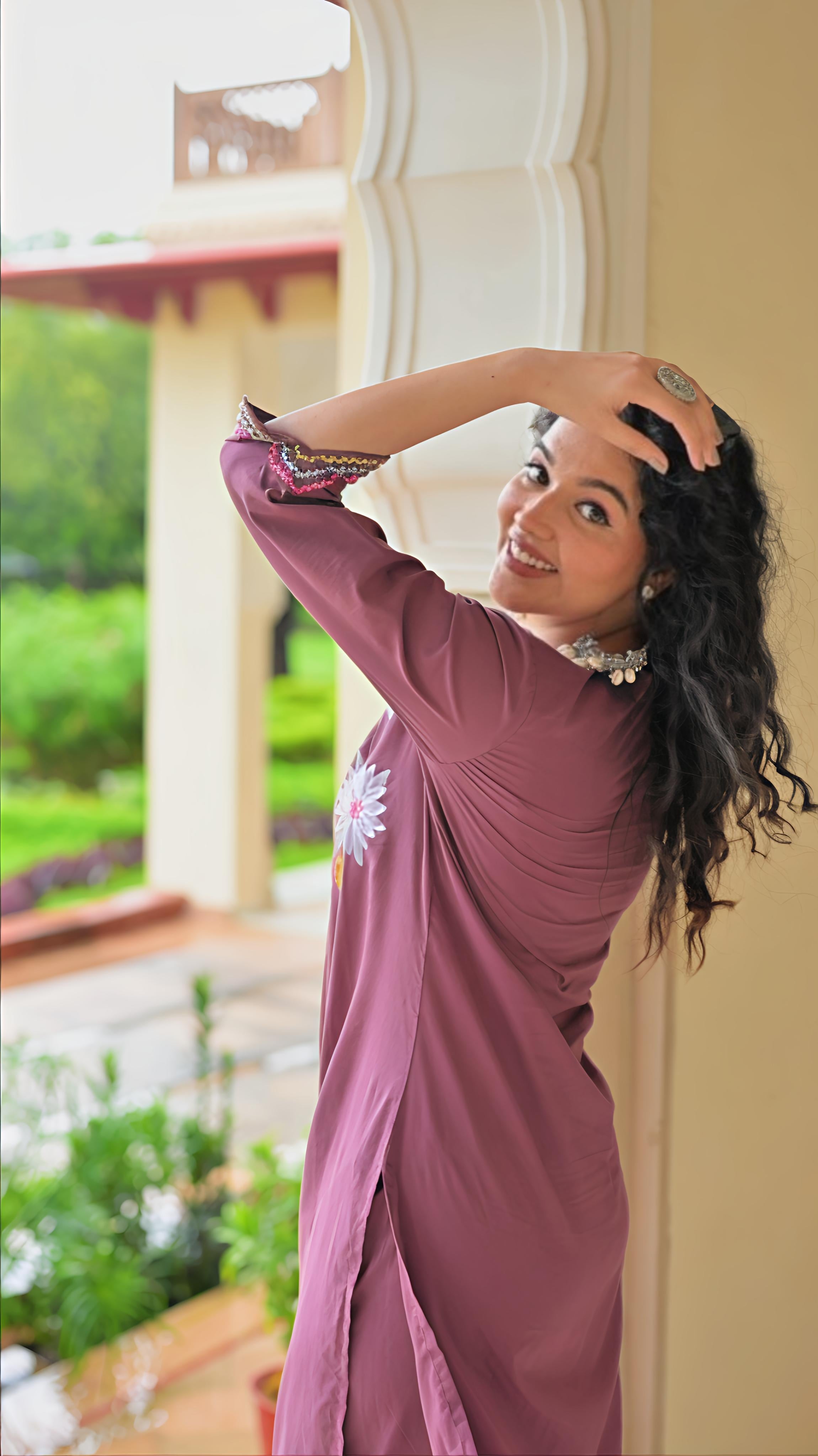 Elegant woman in traditional Indian kurta set posing outdoors with lush greenery in the background