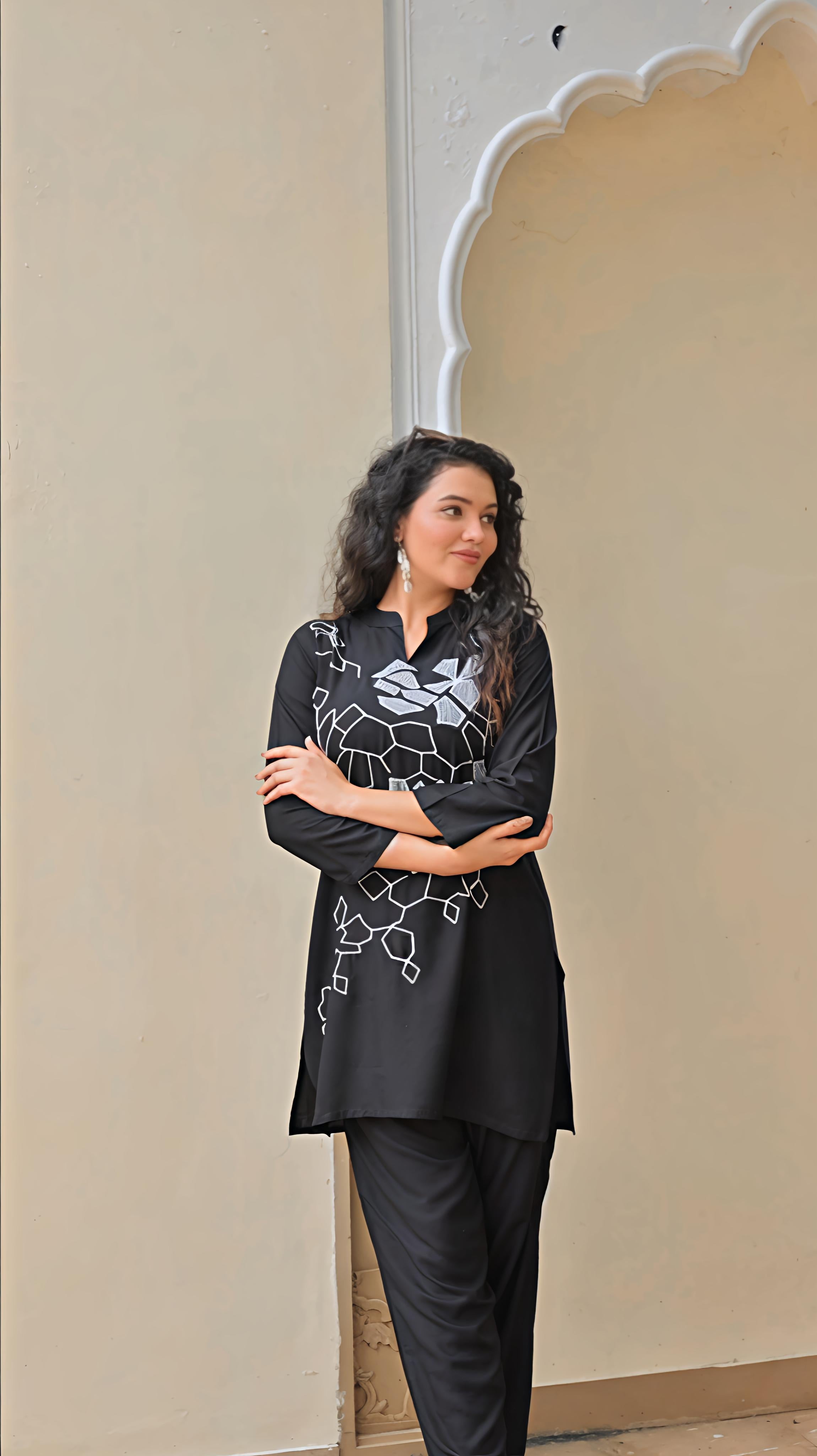 Elegant women's embroidered kurta set in black featuring intricate designs and a stylish silhouette