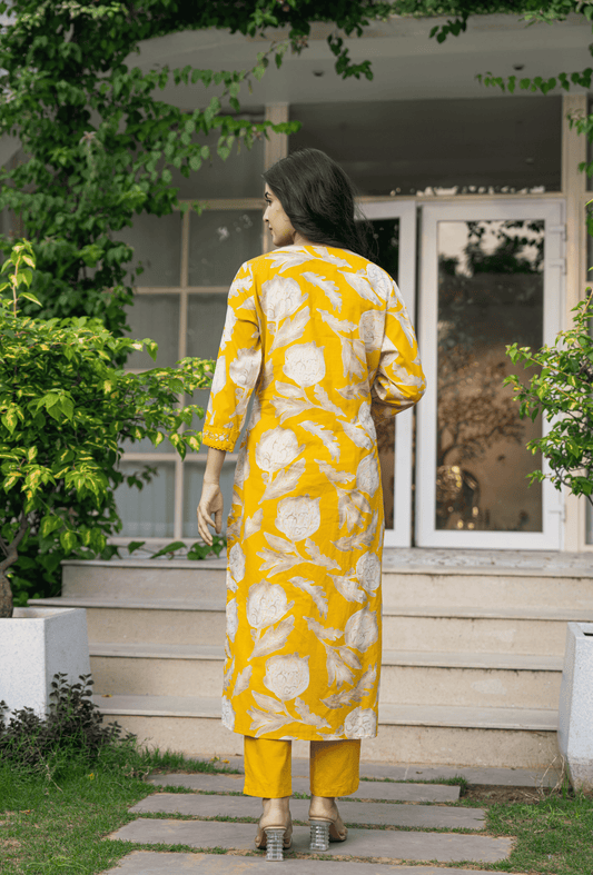 Back view of a vibrant yellow Indian cotton suit online with floral patterns, perfect for casual wear
